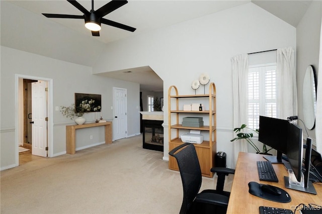 carpeted office space with ceiling fan and vaulted ceiling