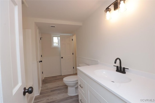 bathroom featuring toilet, vanity, and wood-type flooring