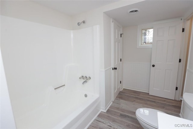 bathroom featuring shower / bath combination, toilet, and hardwood / wood-style floors