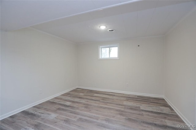 empty room with light hardwood / wood-style flooring and ornamental molding