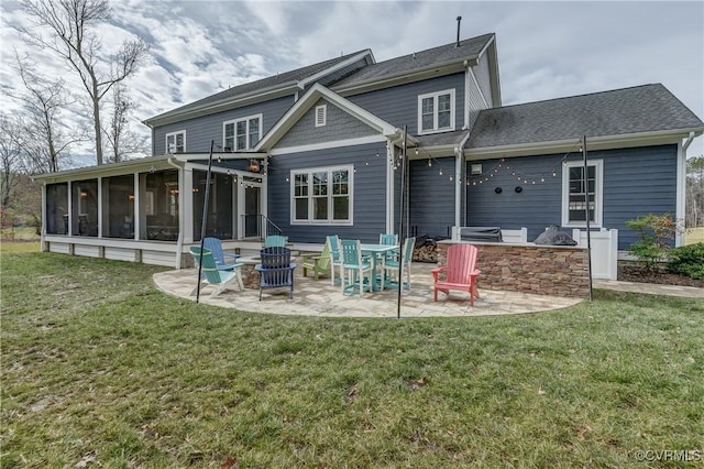 back of property featuring a sunroom, a lawn, an outdoor kitchen, and a patio area