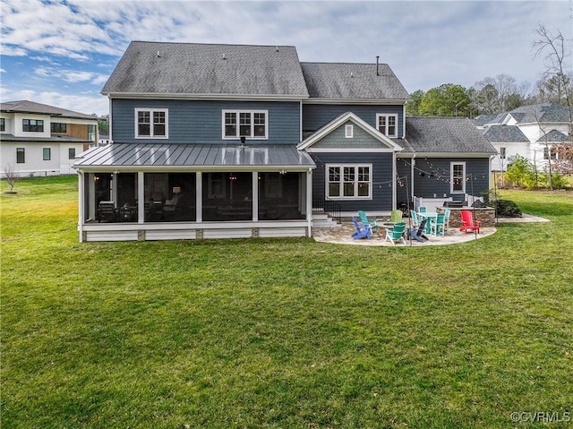 rear view of property with a fire pit, a patio area, a sunroom, and a lawn