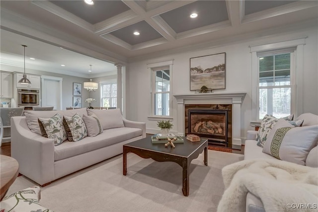 living room featuring light hardwood / wood-style flooring, beam ceiling, coffered ceiling, a fireplace, and ornamental molding