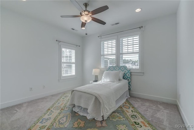 carpeted bedroom featuring multiple windows and ceiling fan