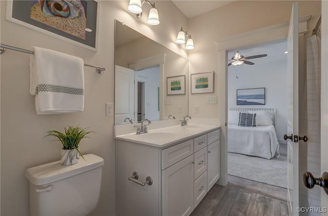 bathroom featuring ceiling fan, vanity, toilet, and hardwood / wood-style floors