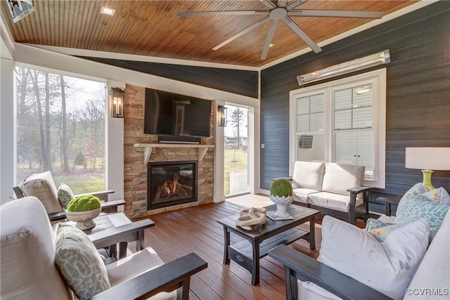 sunroom featuring ceiling fan, a fireplace, vaulted ceiling, and wooden ceiling