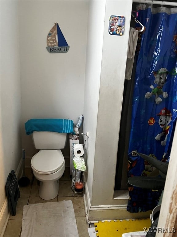 bathroom with tile patterned flooring, toilet, and a shower with shower curtain