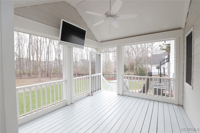 unfurnished sunroom featuring lofted ceiling, plenty of natural light, and ceiling fan