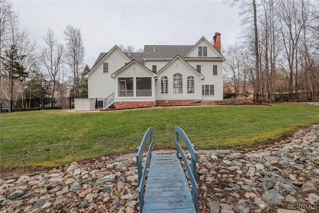 back of property featuring a yard and a sunroom