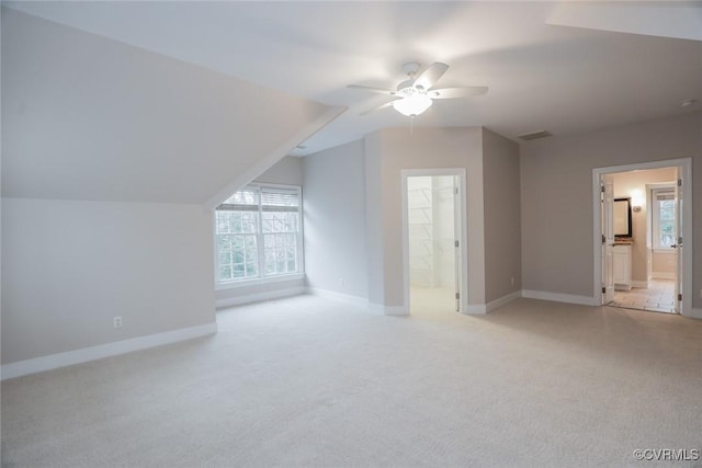 bonus room with ceiling fan, light colored carpet, and vaulted ceiling