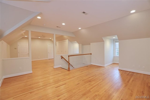 additional living space with lofted ceiling and light hardwood / wood-style flooring