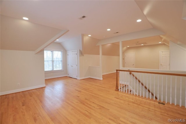 bonus room with vaulted ceiling and light hardwood / wood-style floors