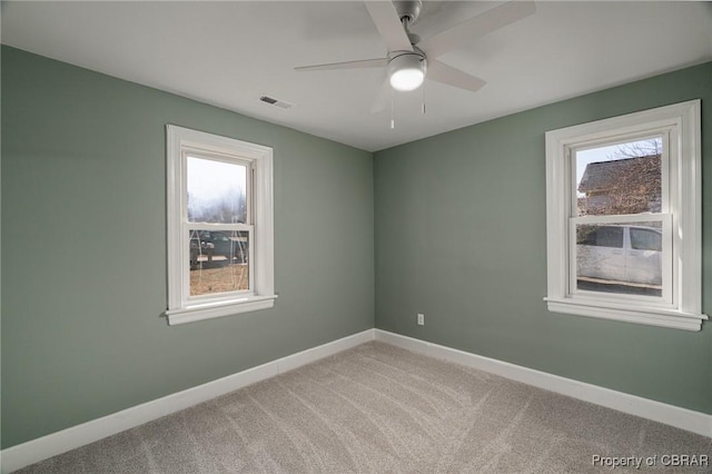 carpeted spare room with ceiling fan