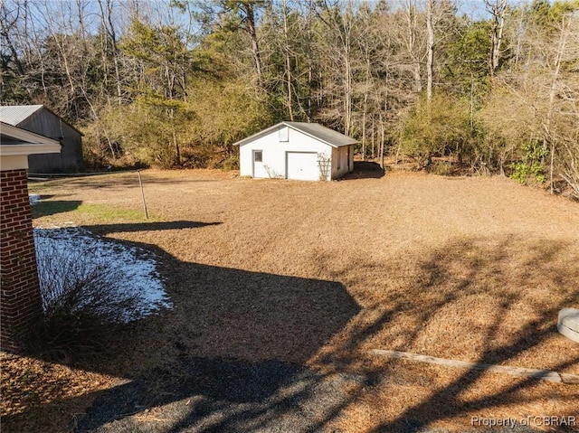 view of yard featuring a garage and an outdoor structure