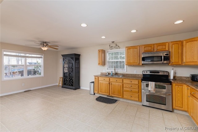 kitchen featuring sink, dark stone counters, ceiling fan, and appliances with stainless steel finishes