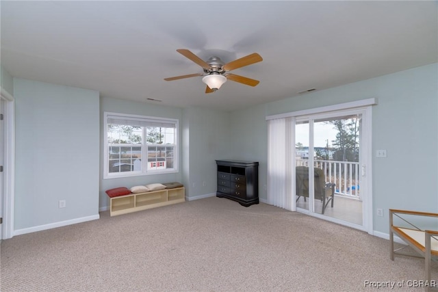 unfurnished living room with visible vents, carpet flooring, baseboards, and ceiling fan