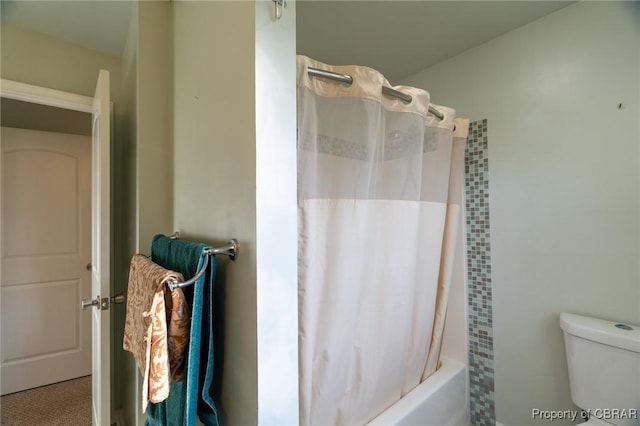 bathroom featuring shower / tub combo with curtain and toilet