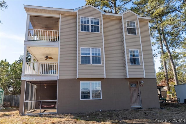 rear view of property with ceiling fan and a balcony