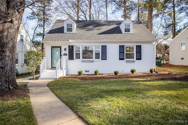 cape cod home featuring a front yard