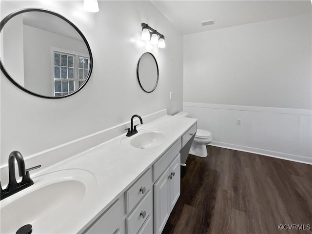 bathroom with vanity, toilet, and hardwood / wood-style floors