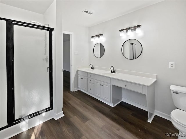 bathroom with vanity, hardwood / wood-style floors, walk in shower, and toilet