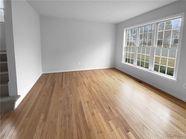 empty room with light hardwood / wood-style flooring