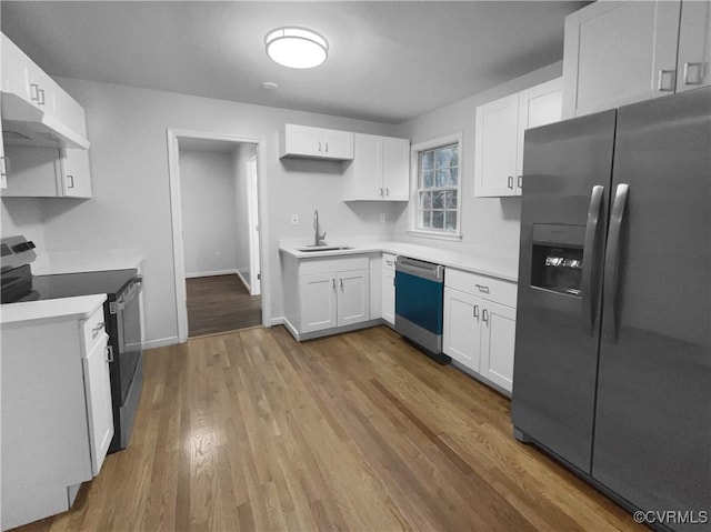 kitchen featuring appliances with stainless steel finishes, sink, white cabinets, and light wood-type flooring