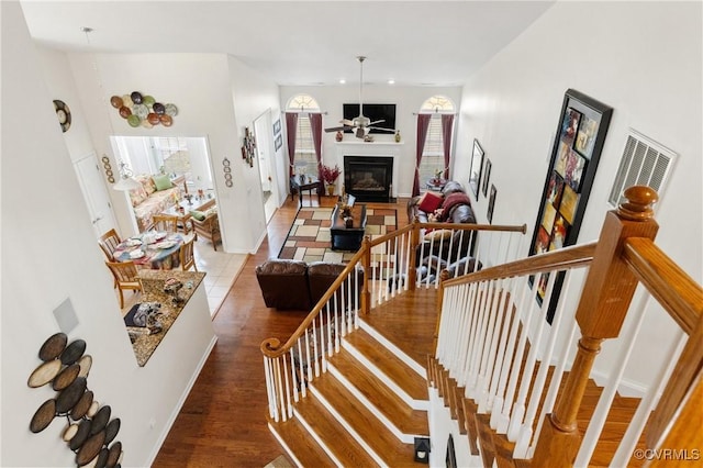 staircase featuring hardwood / wood-style floors and ceiling fan