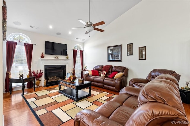 living room featuring vaulted ceiling, ceiling fan, and light wood-type flooring