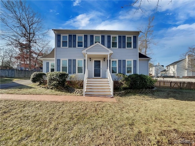 colonial-style house featuring a front lawn