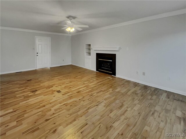 unfurnished living room with built in shelves, ornamental molding, light hardwood / wood-style floors, and ceiling fan