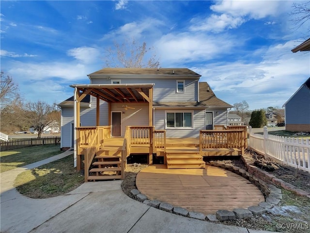 rear view of property featuring a wooden deck and a patio