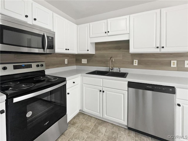 kitchen featuring light tile patterned floors, stainless steel appliances, sink, and white cabinets