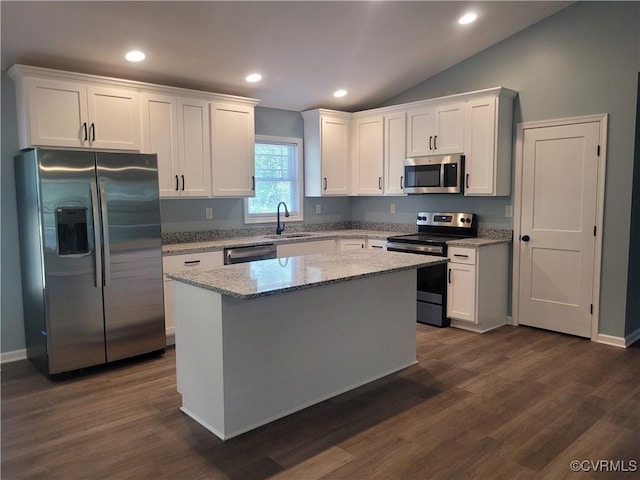 kitchen with white cabinetry, stainless steel appliances, sink, and a kitchen island