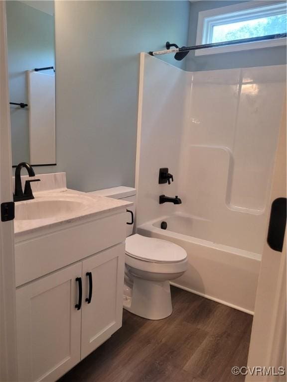 full bathroom with shower / bathing tub combination, hardwood / wood-style floors, vanity, and toilet