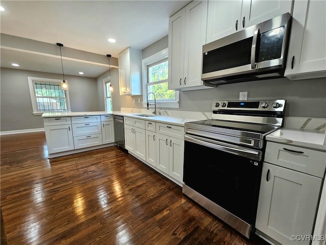 kitchen with pendant lighting, sink, white cabinetry, stainless steel appliances, and kitchen peninsula