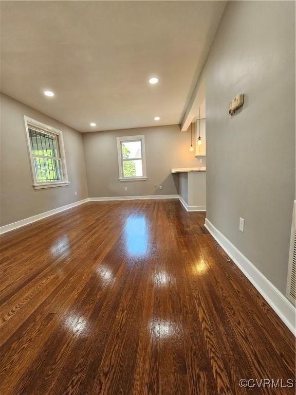 unfurnished living room with dark wood-type flooring