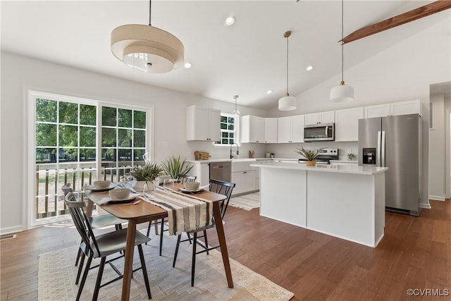 dining room featuring high vaulted ceiling, sink, and dark hardwood / wood-style flooring