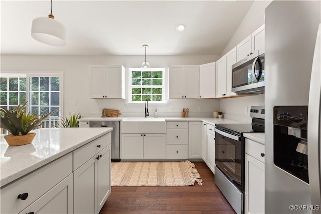 kitchen featuring hanging light fixtures, stainless steel appliances, and white cabinets