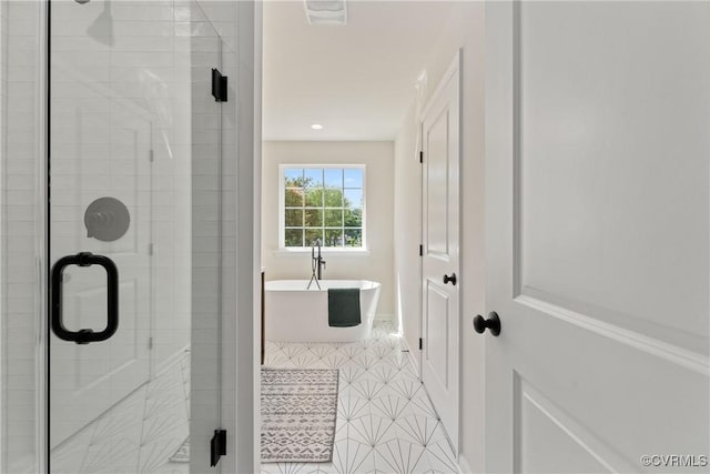 bathroom with tile patterned floors and separate shower and tub