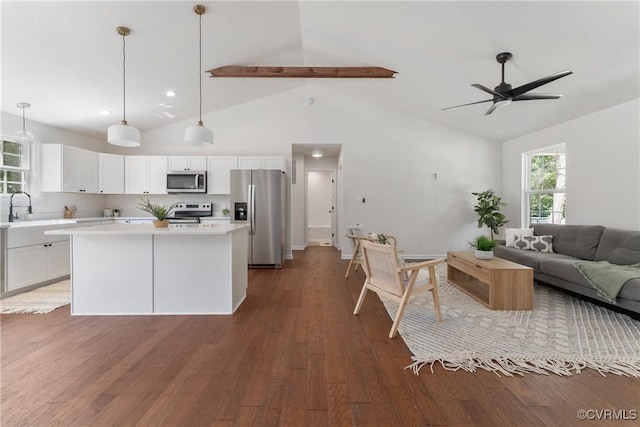 kitchen with white cabinetry, decorative light fixtures, a center island, appliances with stainless steel finishes, and dark hardwood / wood-style flooring