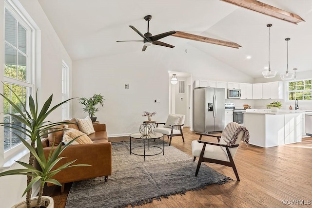 living room with beamed ceiling, ceiling fan, high vaulted ceiling, and light hardwood / wood-style flooring