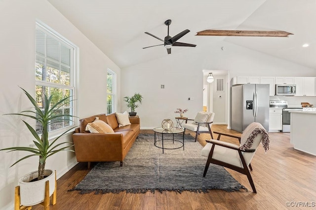 living room with beamed ceiling, high vaulted ceiling, ceiling fan, and light hardwood / wood-style flooring