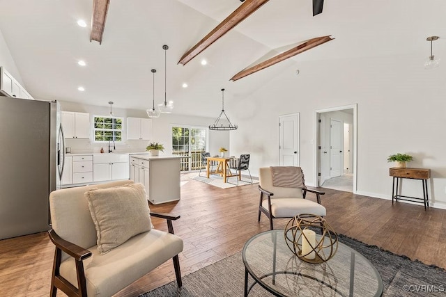 living room with high vaulted ceiling, light hardwood / wood-style floors, and sink