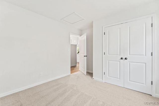 unfurnished bedroom with a closet and light carpet