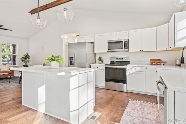 kitchen featuring pendant lighting, appliances with stainless steel finishes, white cabinets, a kitchen island, and light wood-type flooring