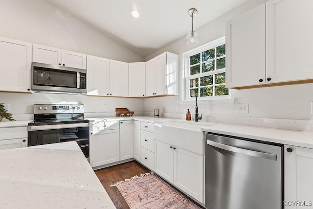 kitchen featuring stainless steel appliances, vaulted ceiling, hanging light fixtures, and white cabinets