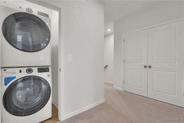 washroom with stacked washer and dryer and light colored carpet