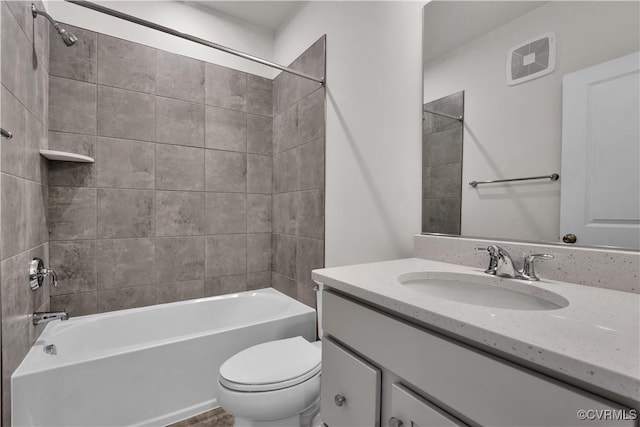 bathroom with visible vents, toilet, vanity, and shower / tub combination