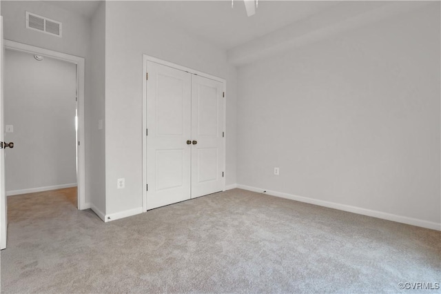 unfurnished bedroom with visible vents, baseboards, a closet, and carpet flooring